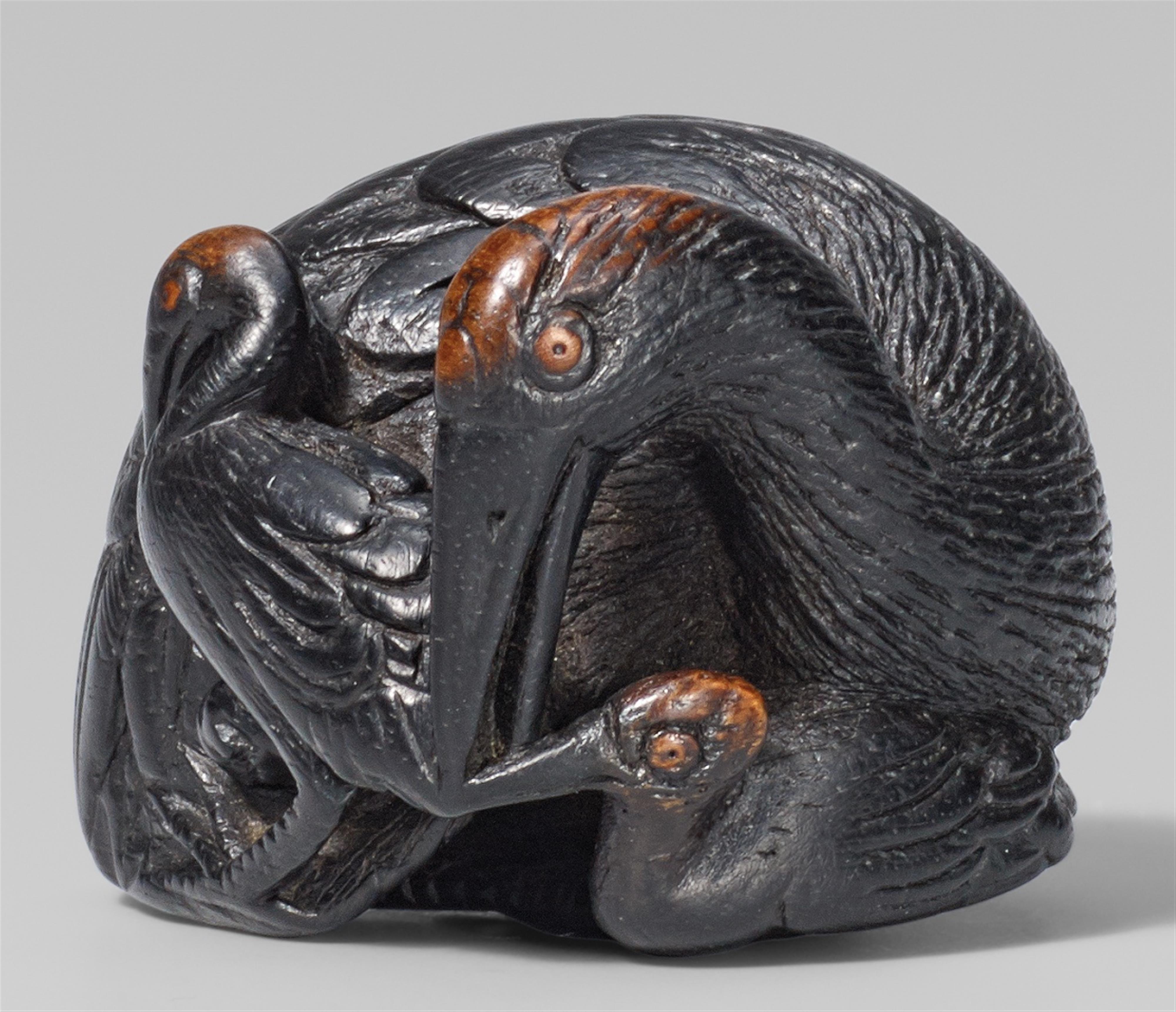 A black wood netsuke of a crane and two young. 19th century - image-1
