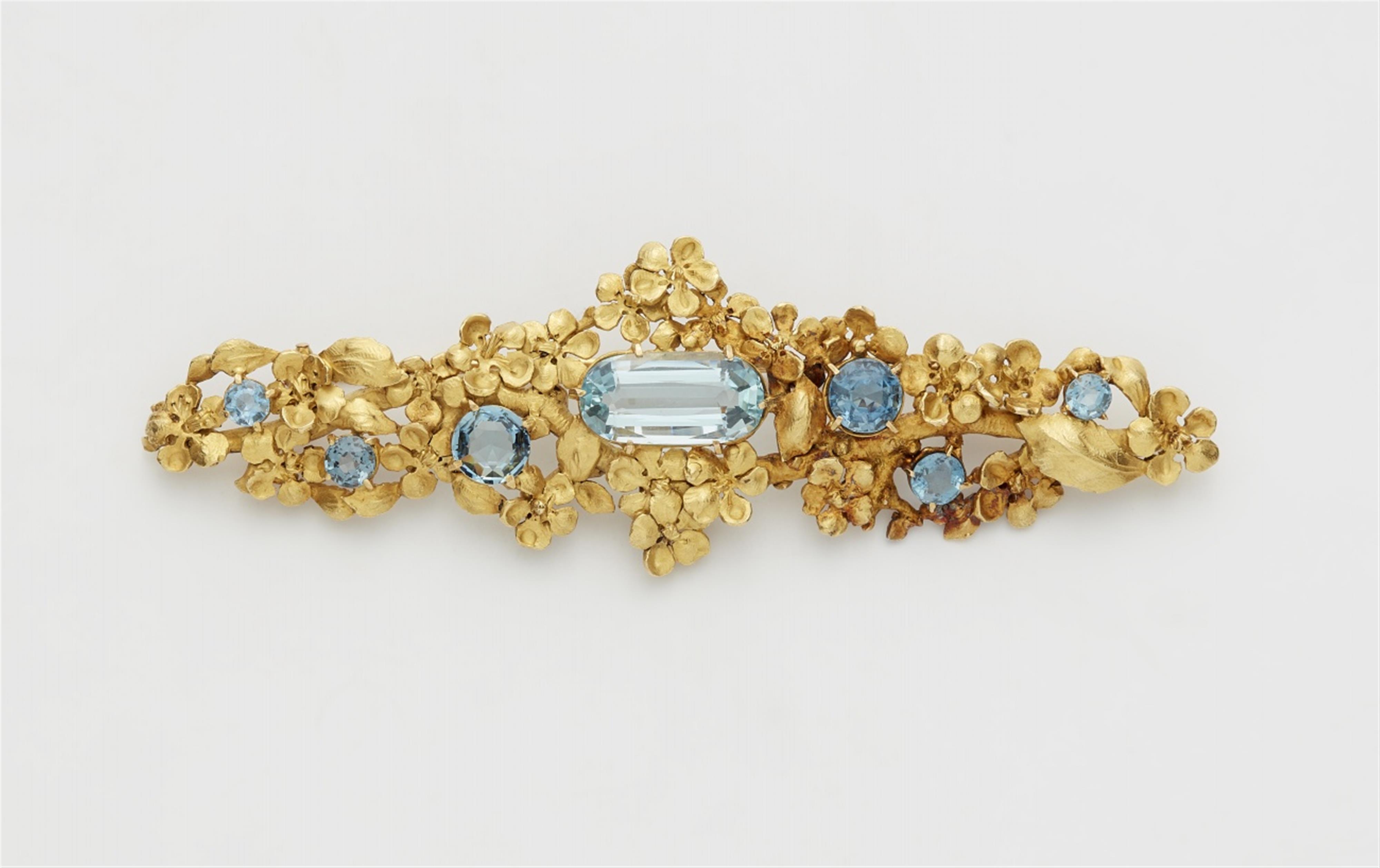 An 18k gold floral brooch with blue topaz - image-1