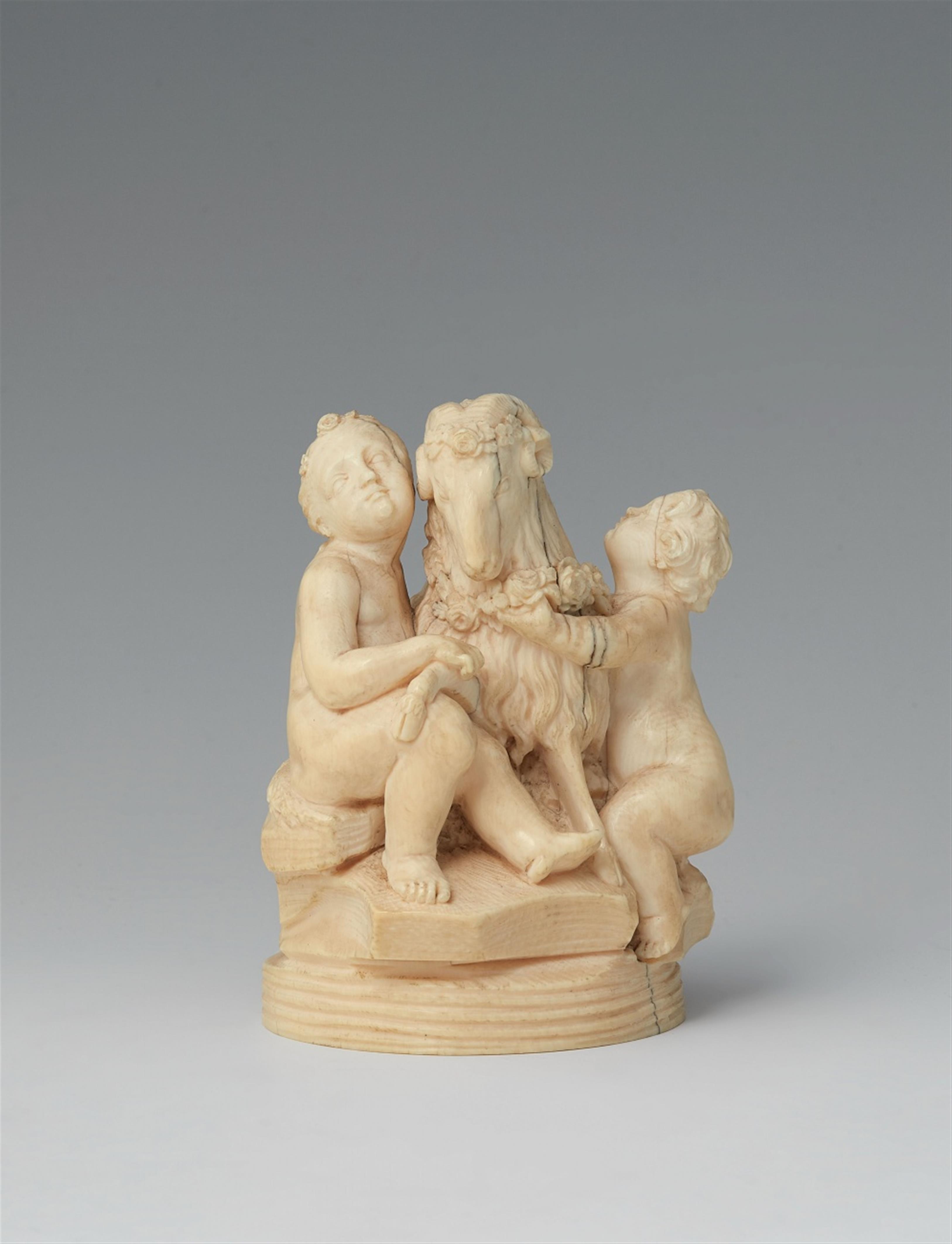 A carved ivory group of two putti with a ram - image-1