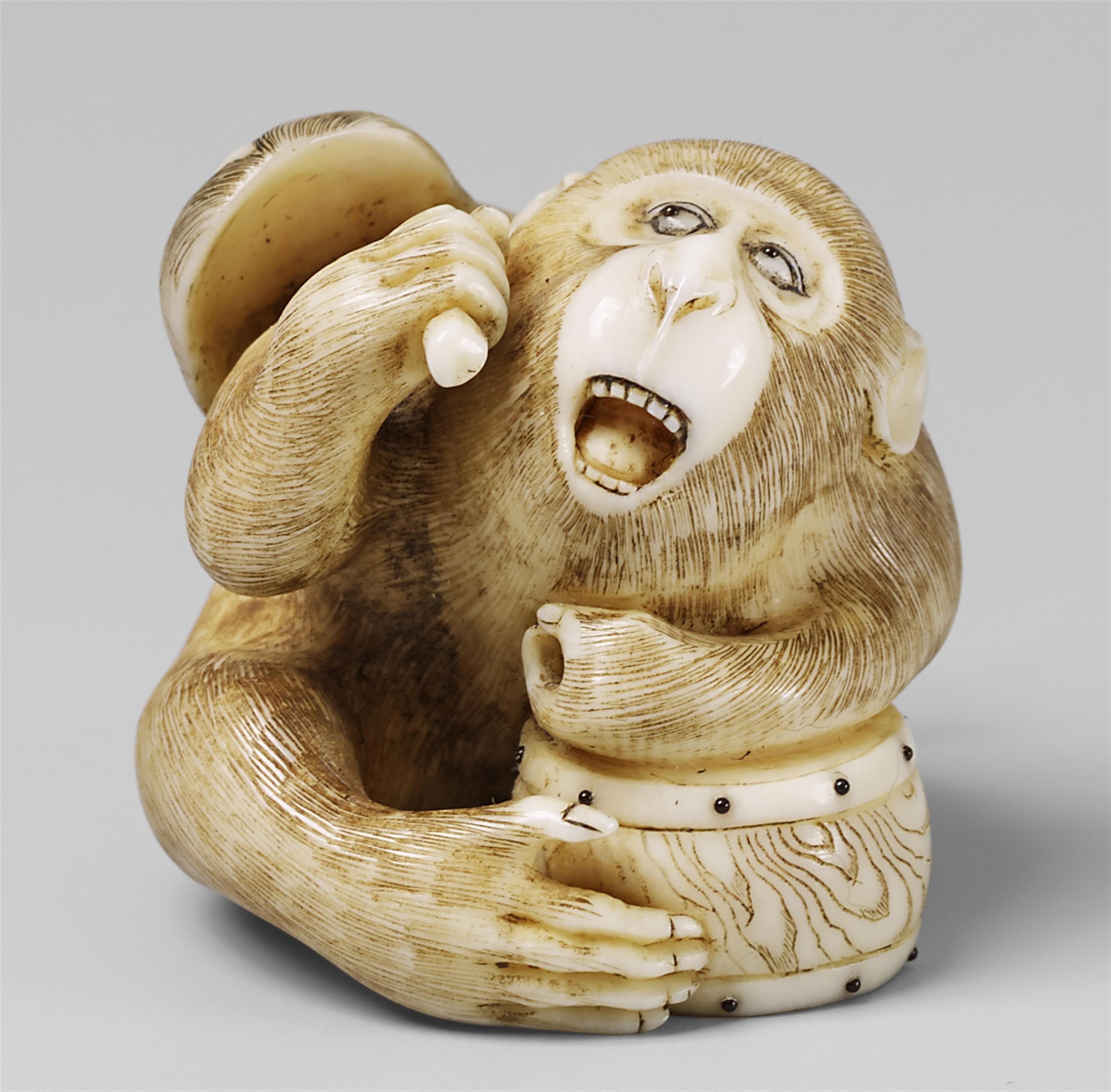 An ivory netsuke of a monkey with a mask and a drum. Late 19th century - image-1