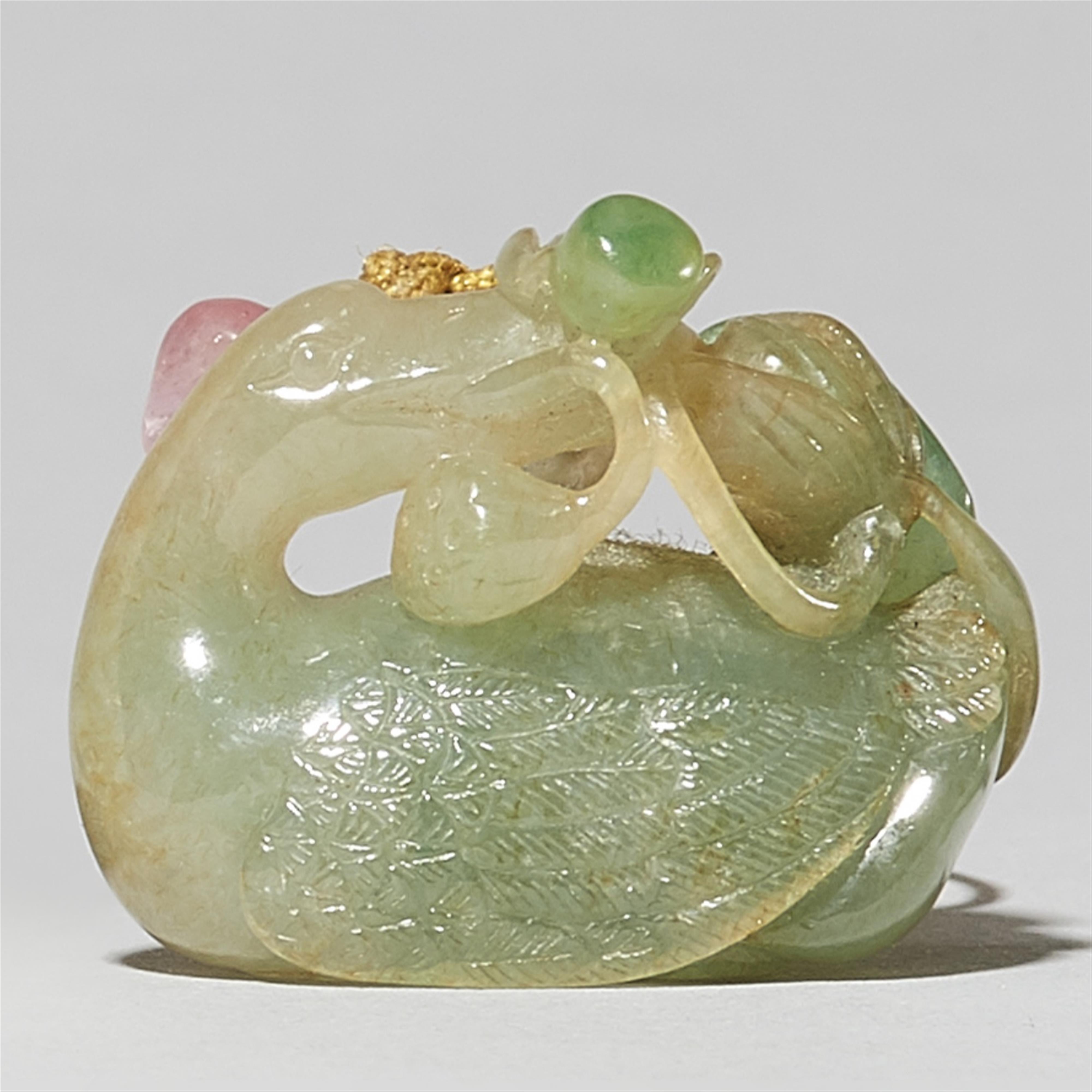 A small greenish jade pendant - image-1