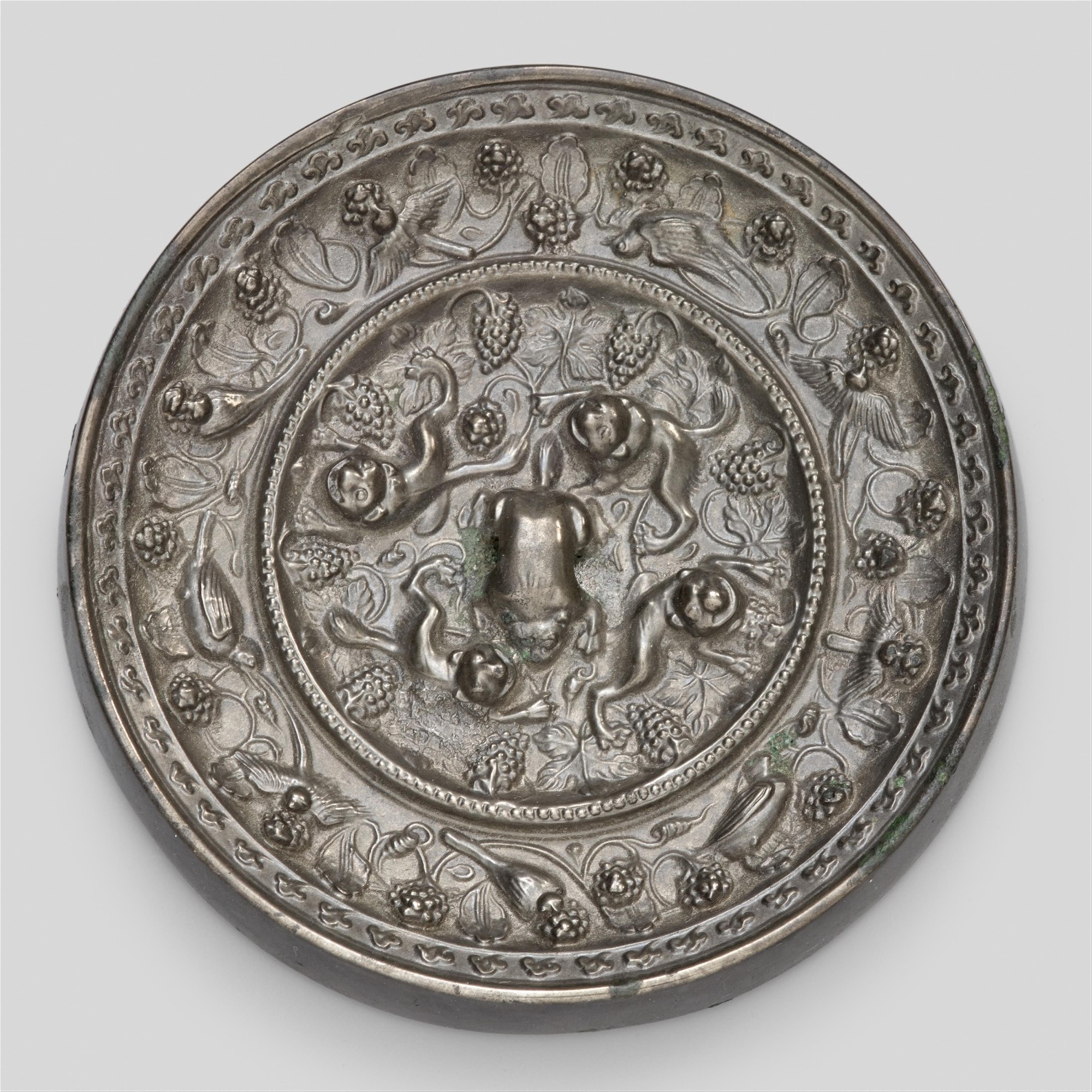 A silvery bronze round lion and grapevine mirror. Tang dynasty, 7th/8th century - image-1
