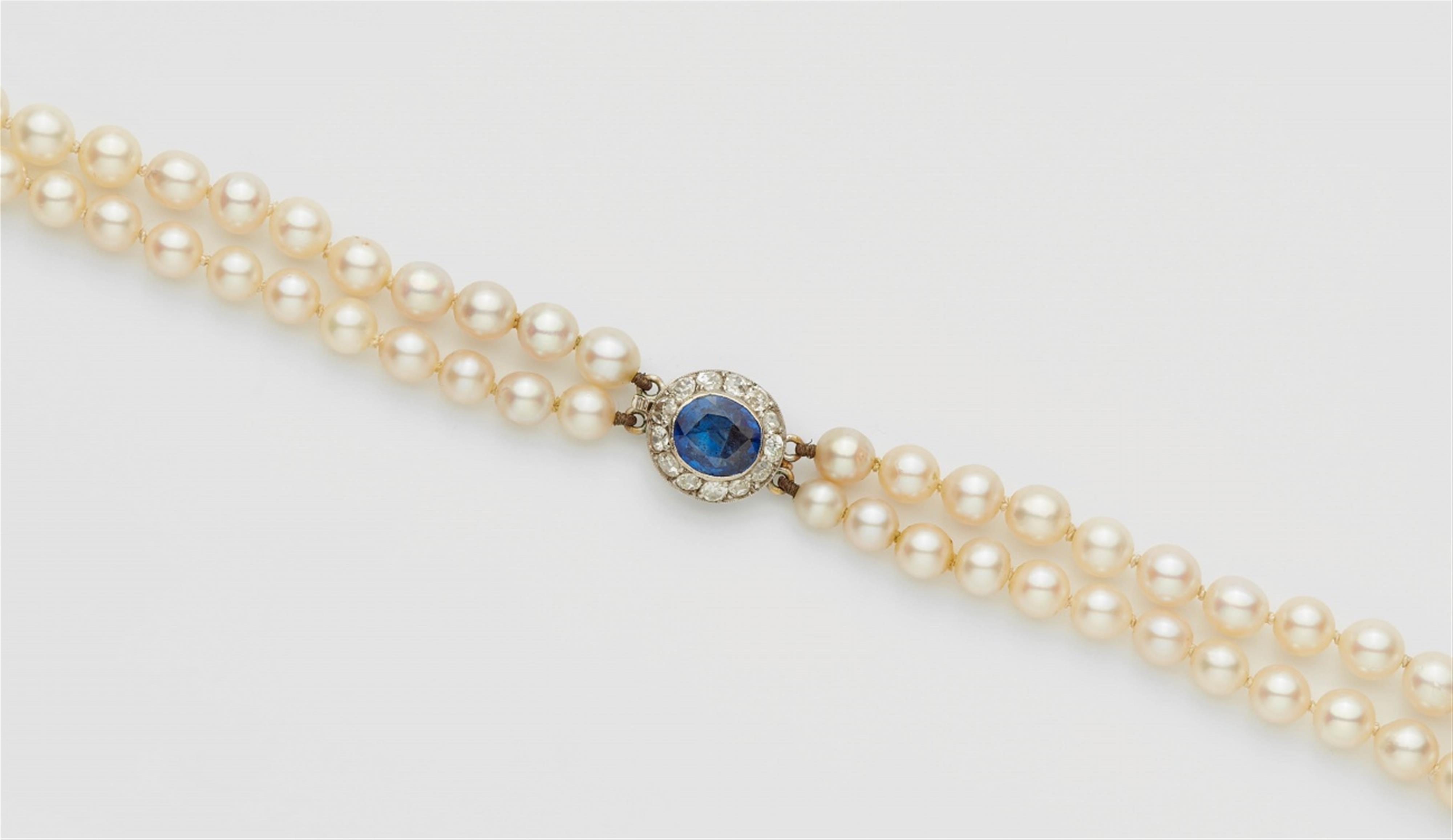A pearl necklace with a diamond and sapphire clasp - image-1
