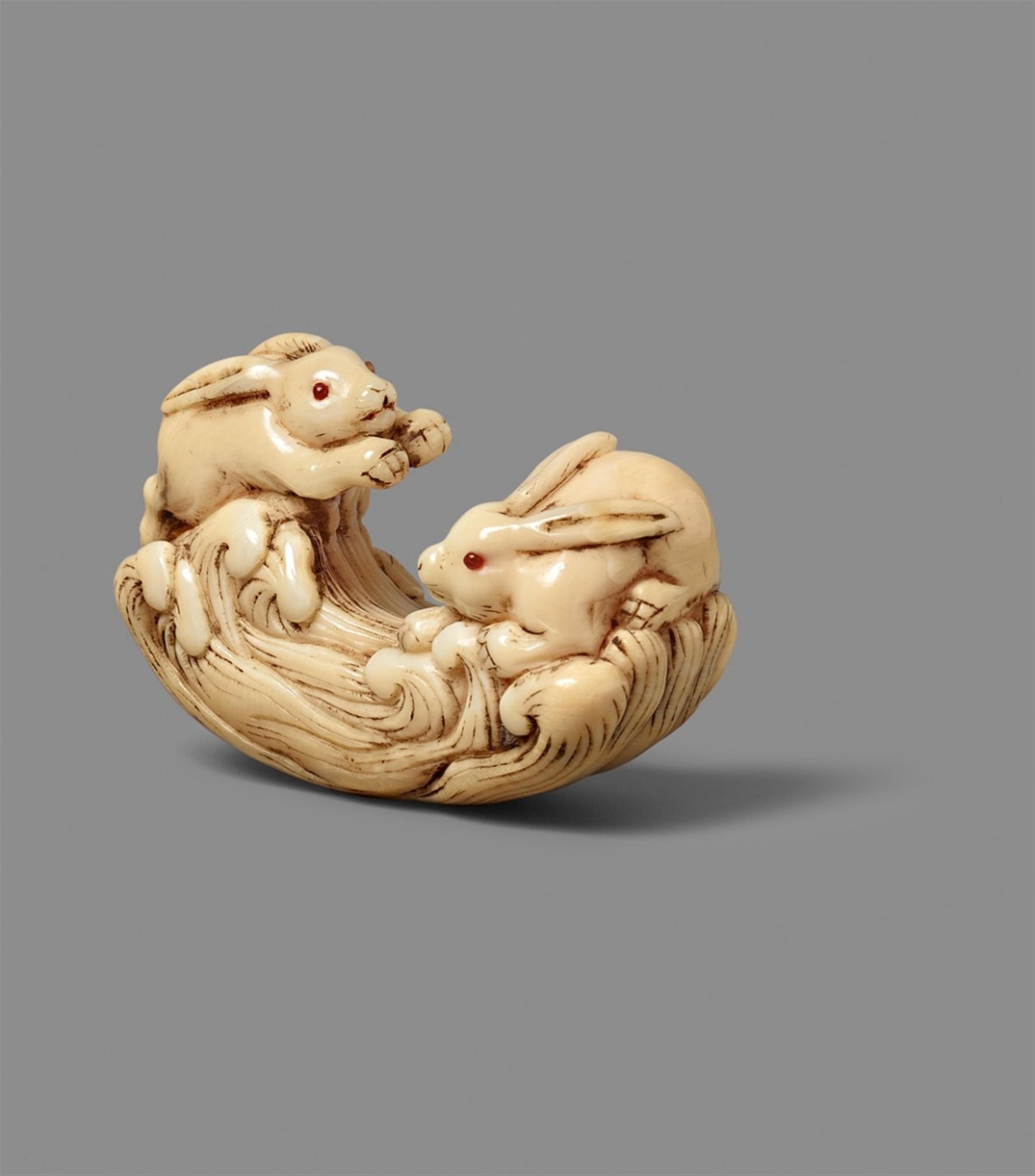 A marine ivory netsuke of two hares jumping over waves. 18th century - image-1