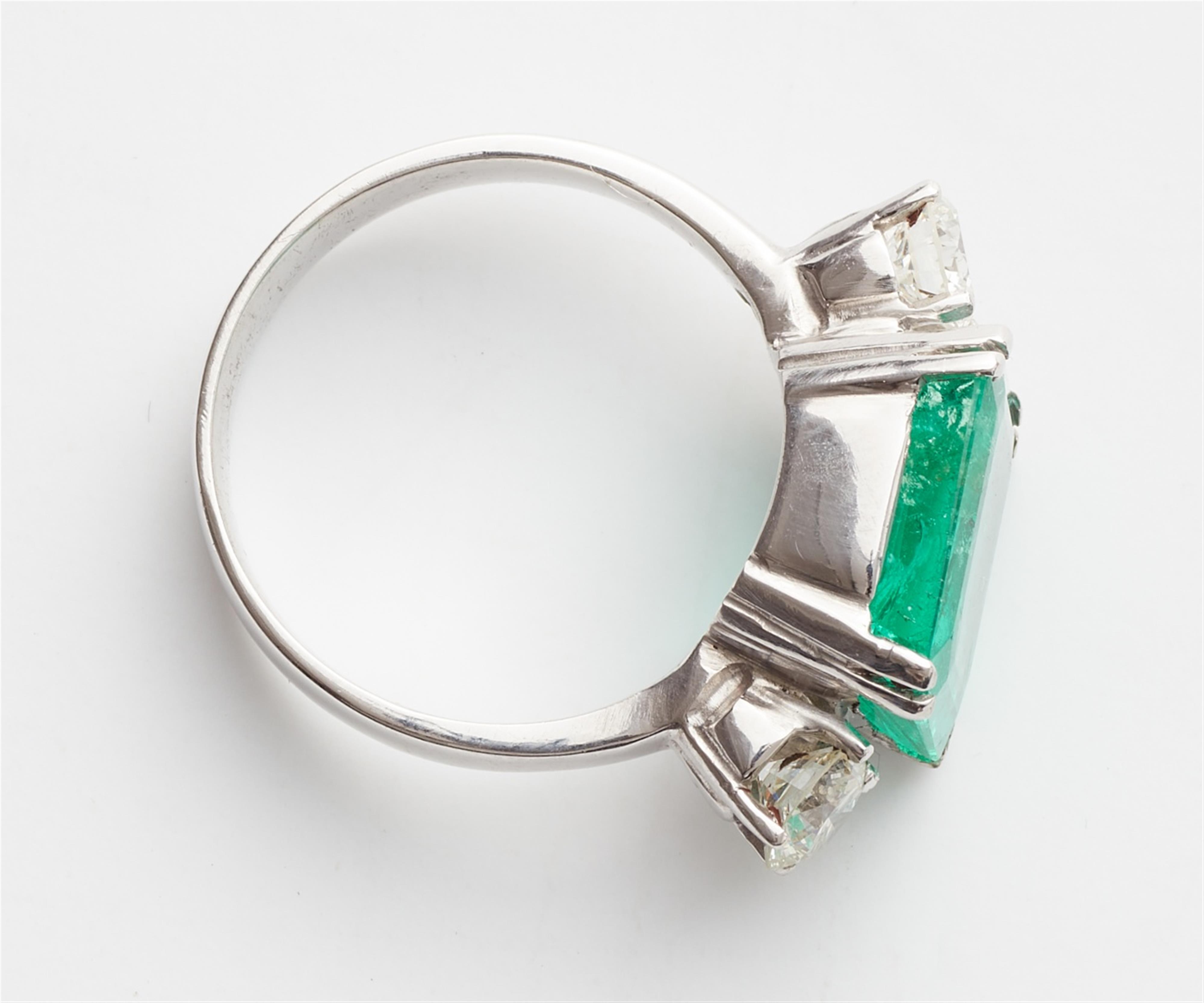 An 18k white gold three stone emerald ring - image-2