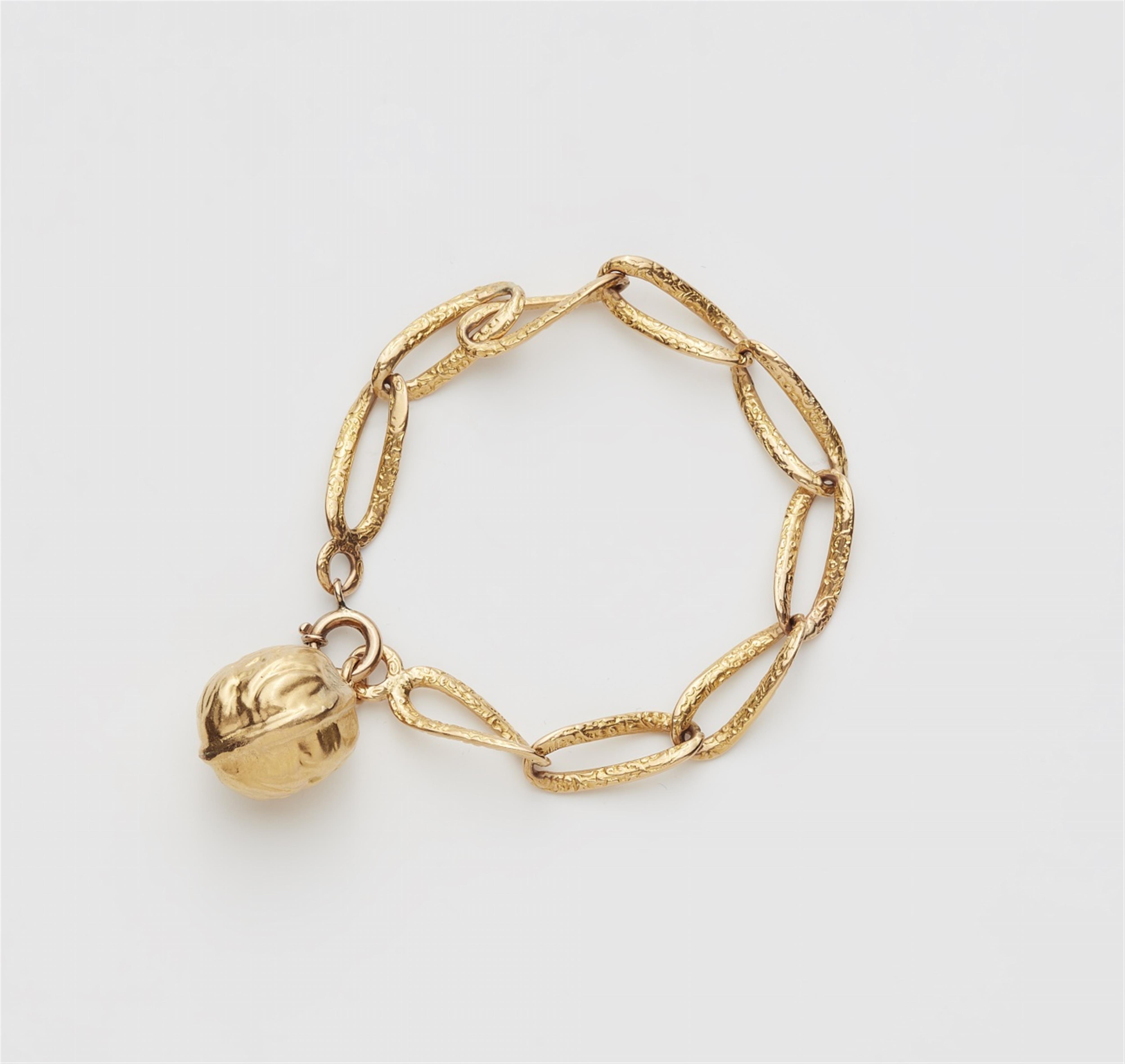 An 18k gold bracelet with a walnut charm - image-1