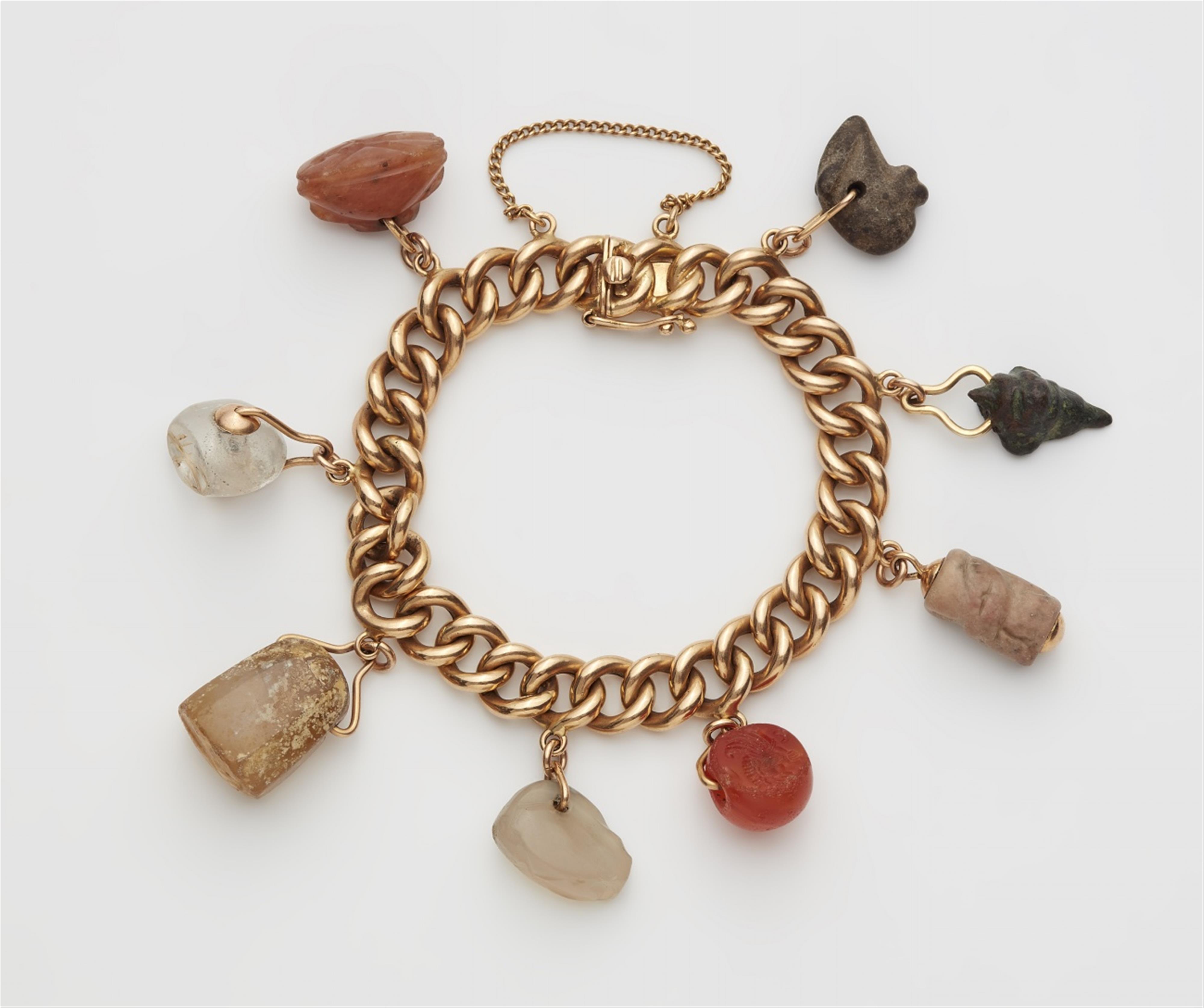 An 18k red gold charm bracelet with ancient amulets - image-1