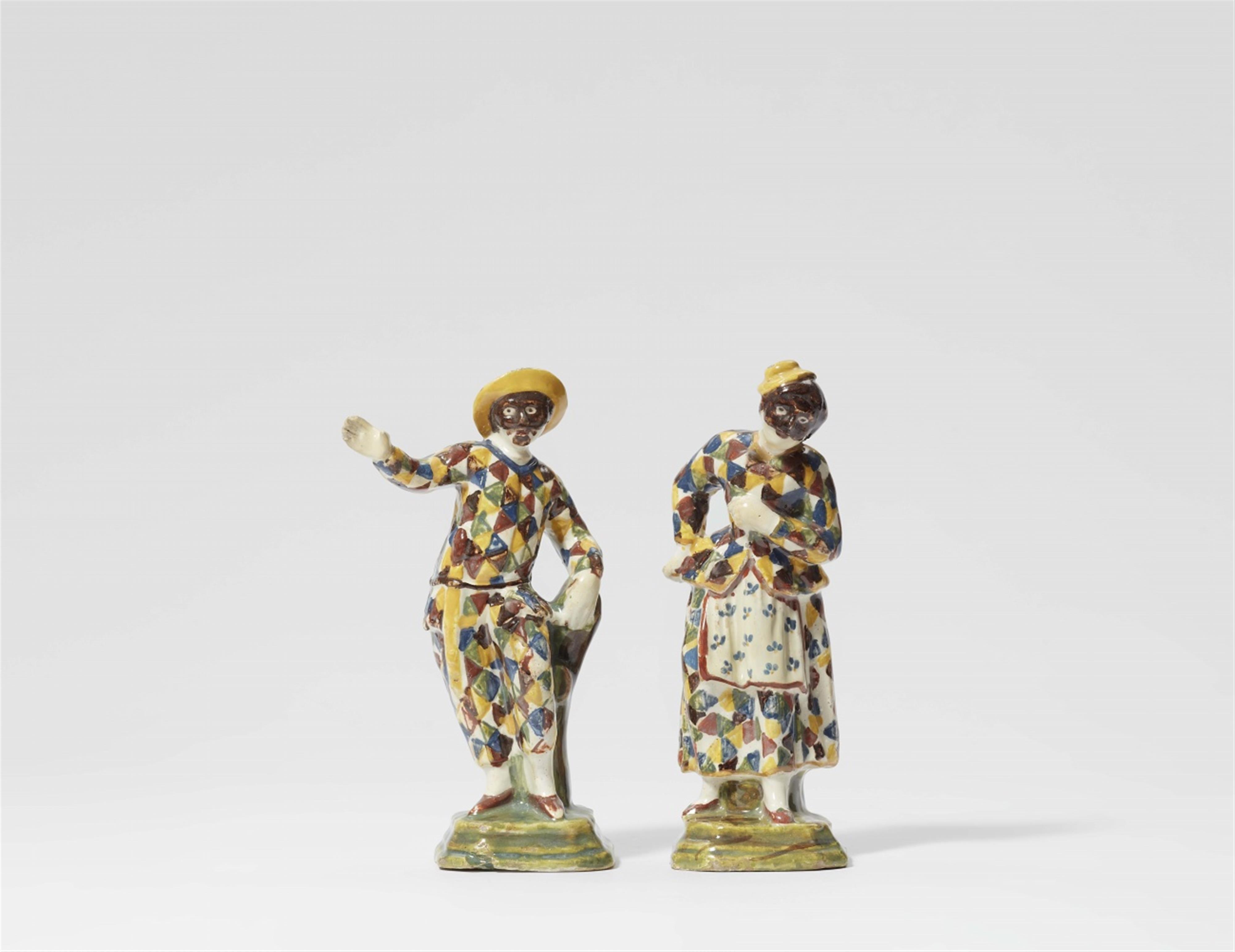 A pair of North Italian majolica figures of Arlecchino and Arlecchina - image-1