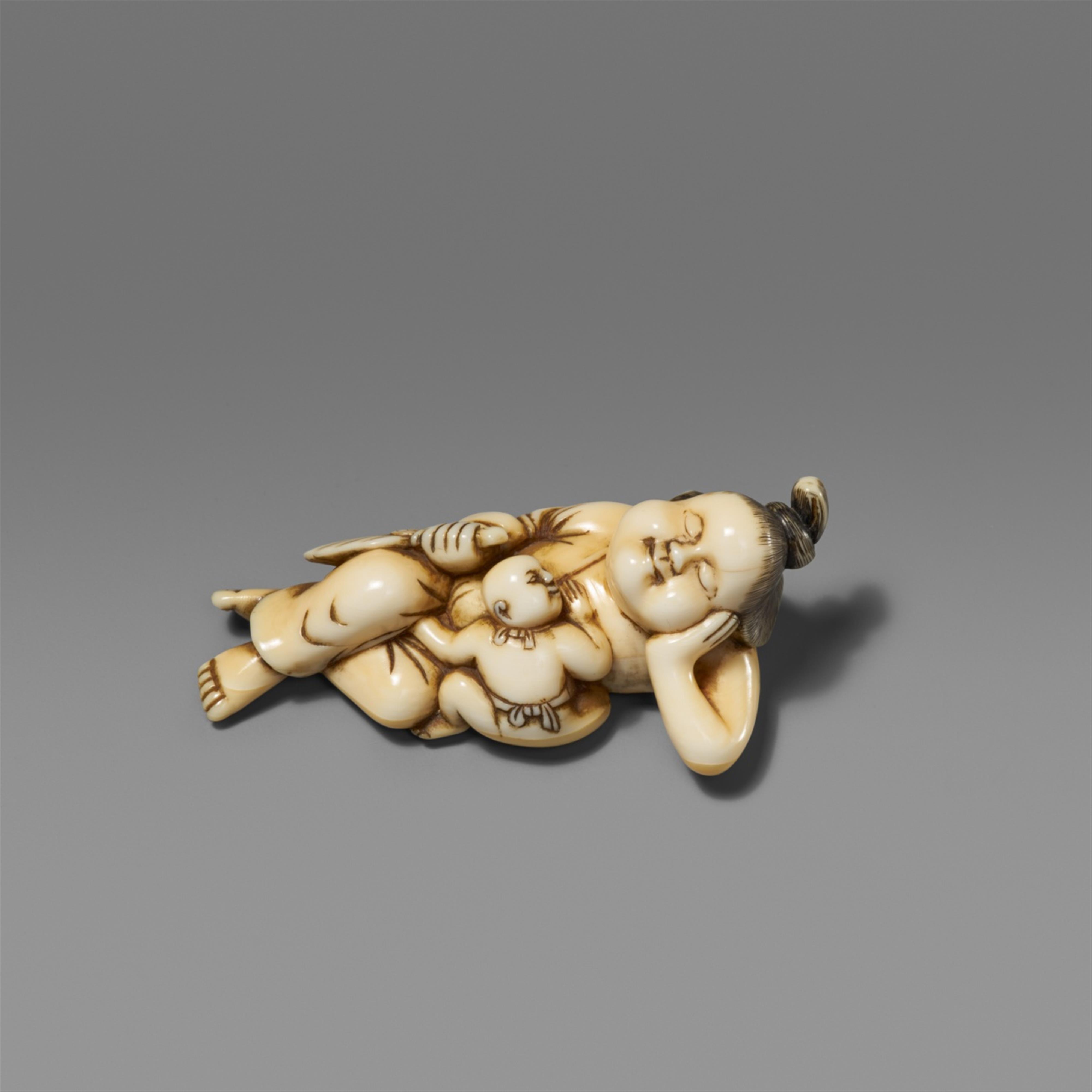 An ivory netsuke of a reclining Okame with a very young boy. Late 18th century - image-1