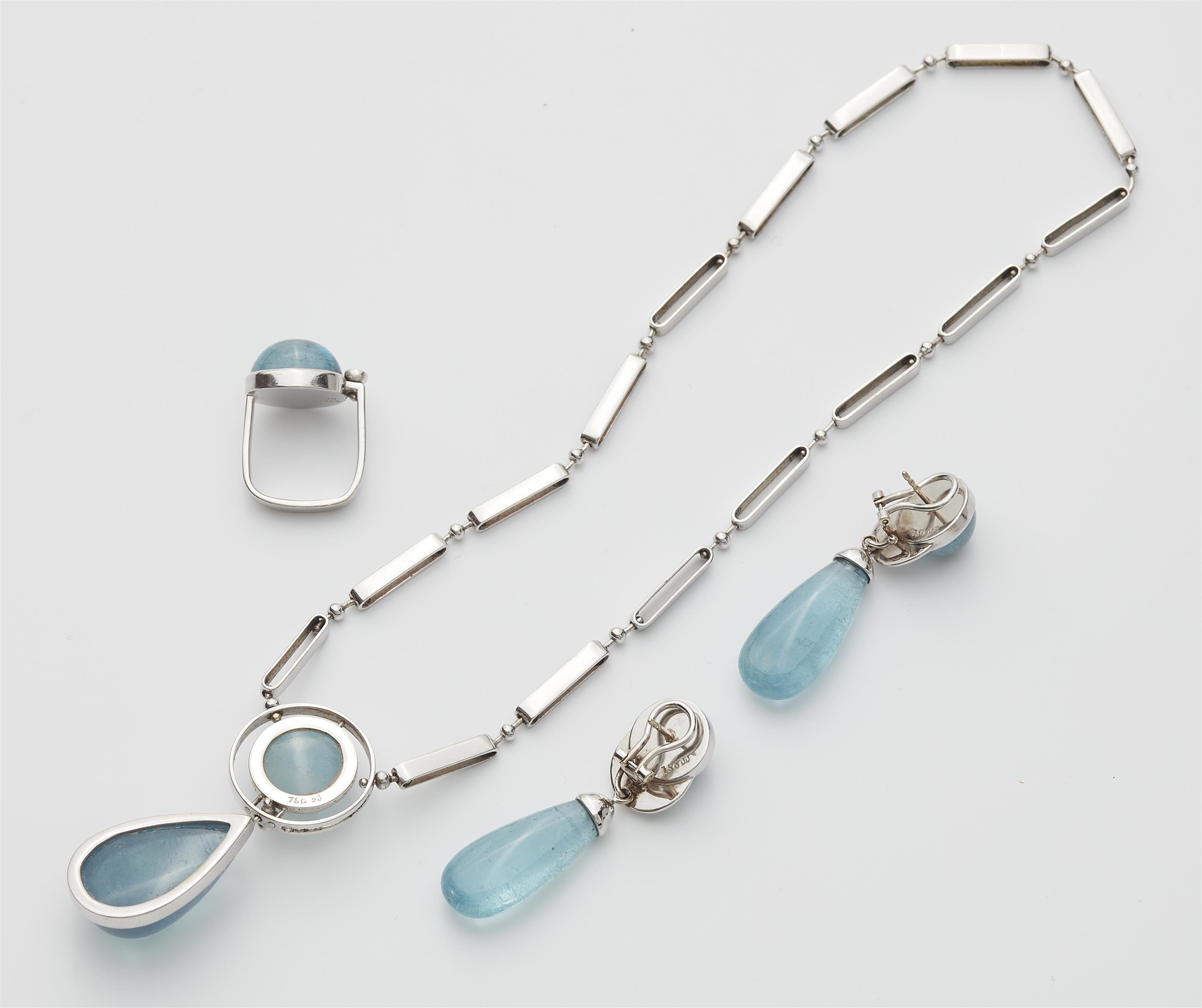 A German 18k white gold diamond and aquamarine cabochon suite comprising a pendant necklace, a pair of earrings and a ring. - image-2