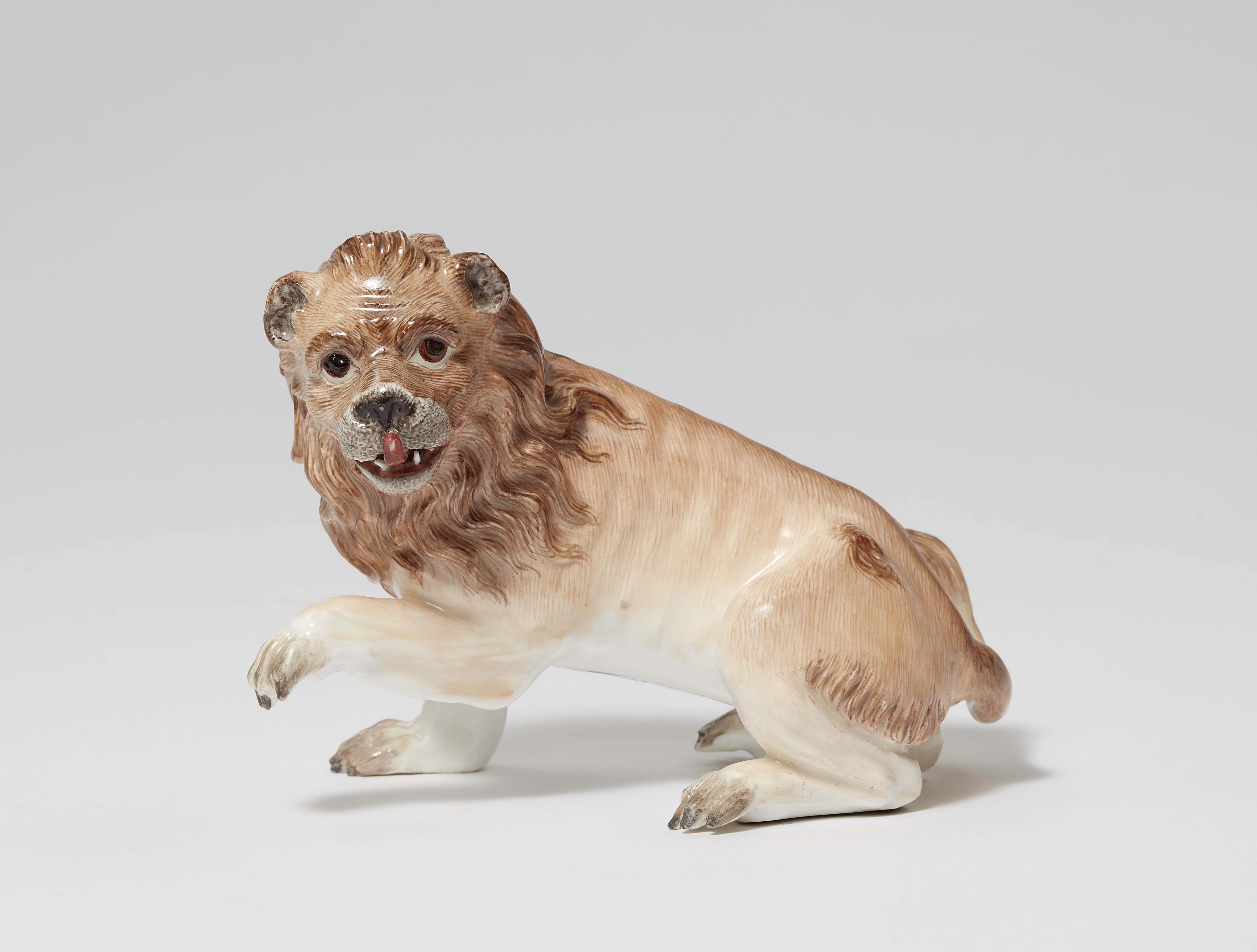 A porcelain model of a lion with a raised paw - image-1