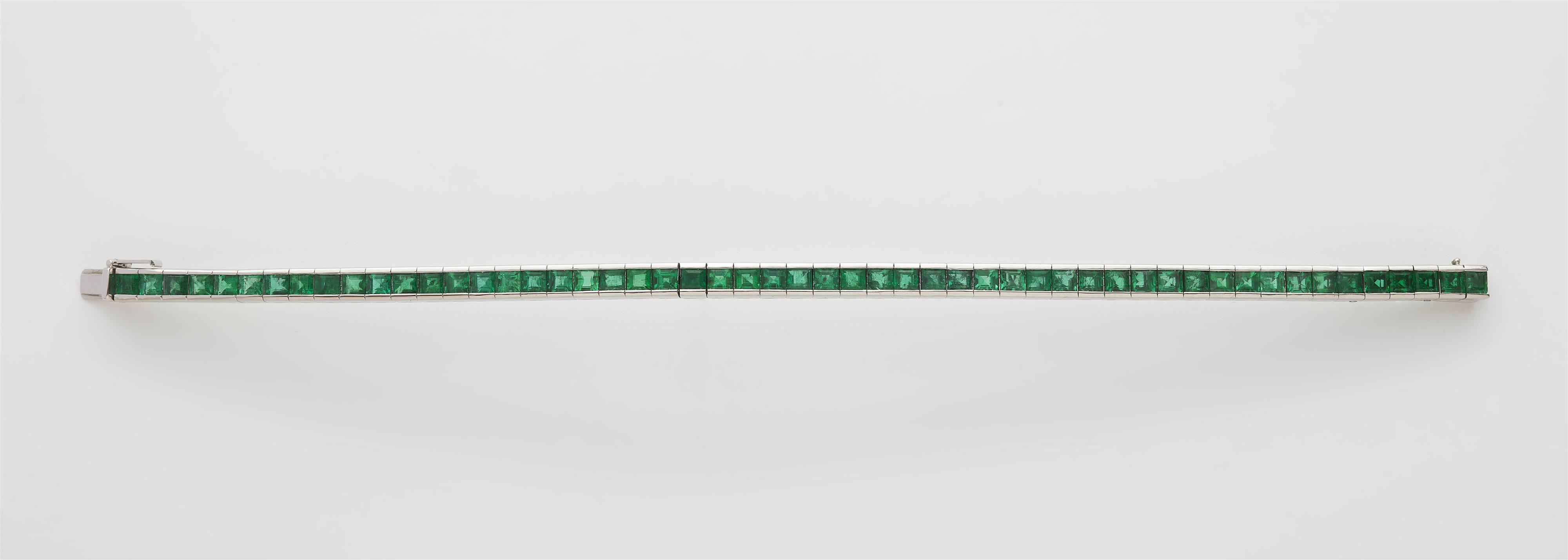 An 18k white gold and carré-cut emerald rivière bracelet. - image-1