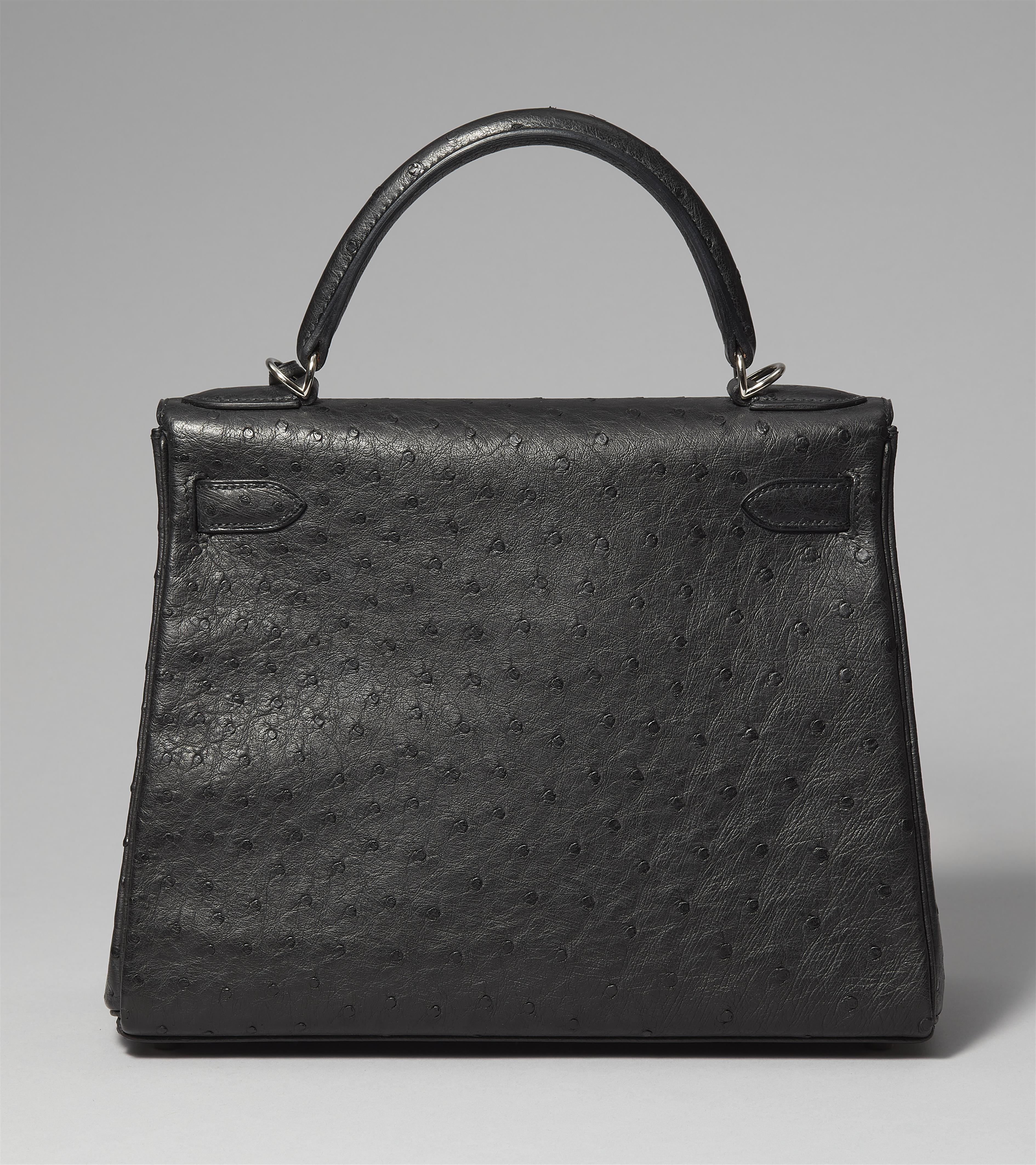 A black ostrich leather Hermès Kelly bag 28 with silver palladium hardware. - image-4