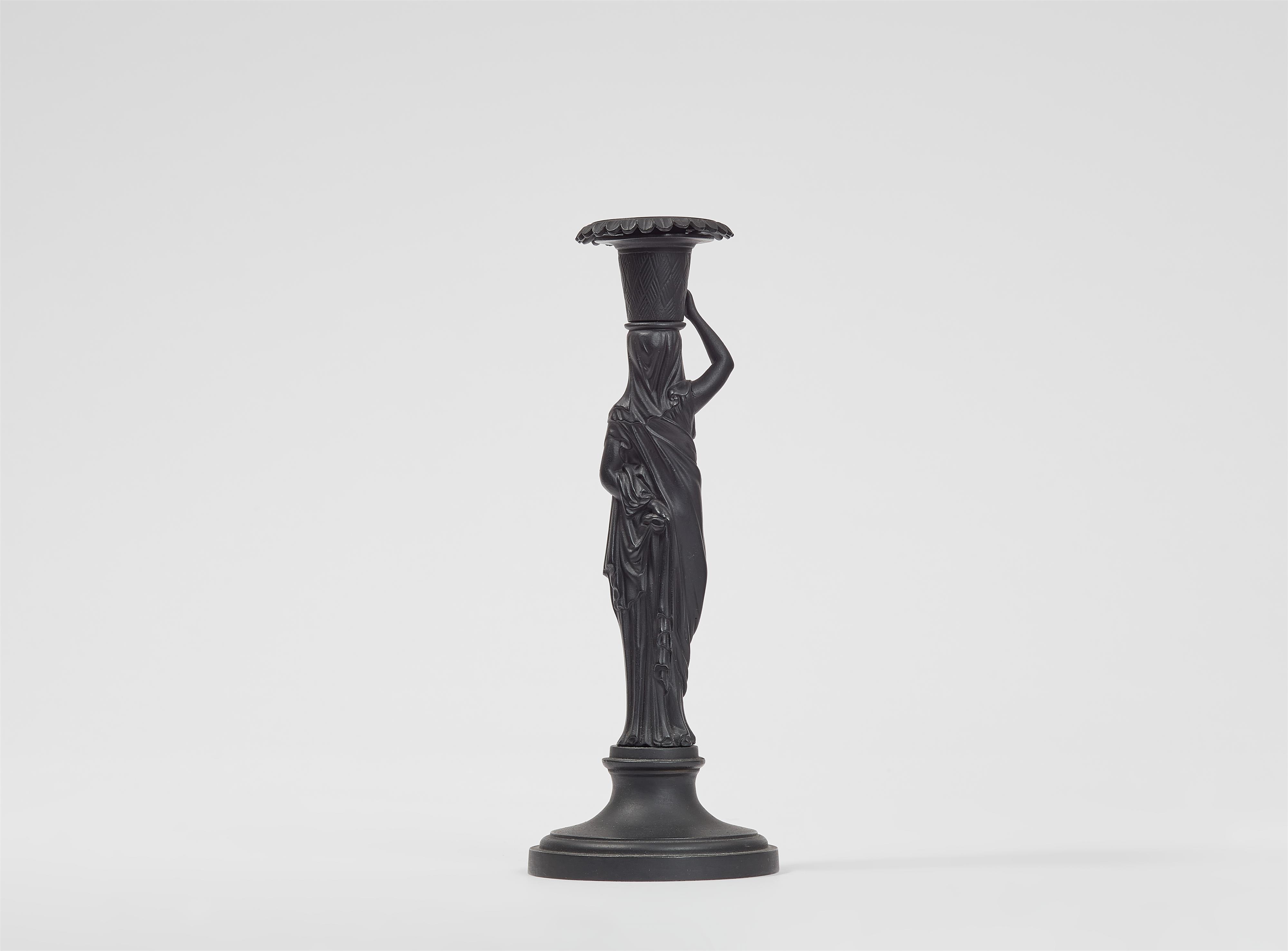 A cast iron candle holder formed as a lady with a basket - image-2