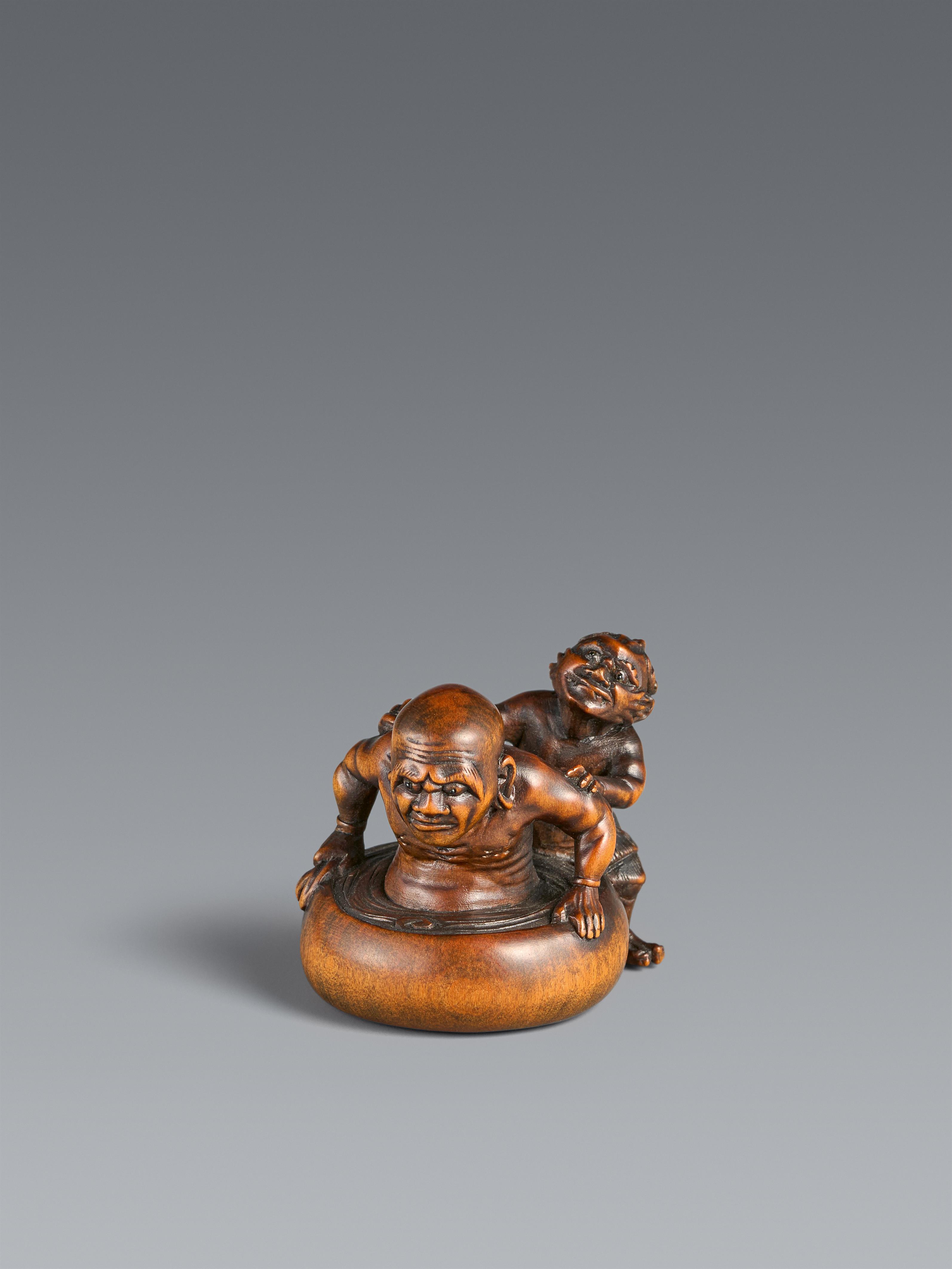 A boxwood netsuke of Daruma or rakan being washed by an oni. Second half 19th entury - image-1