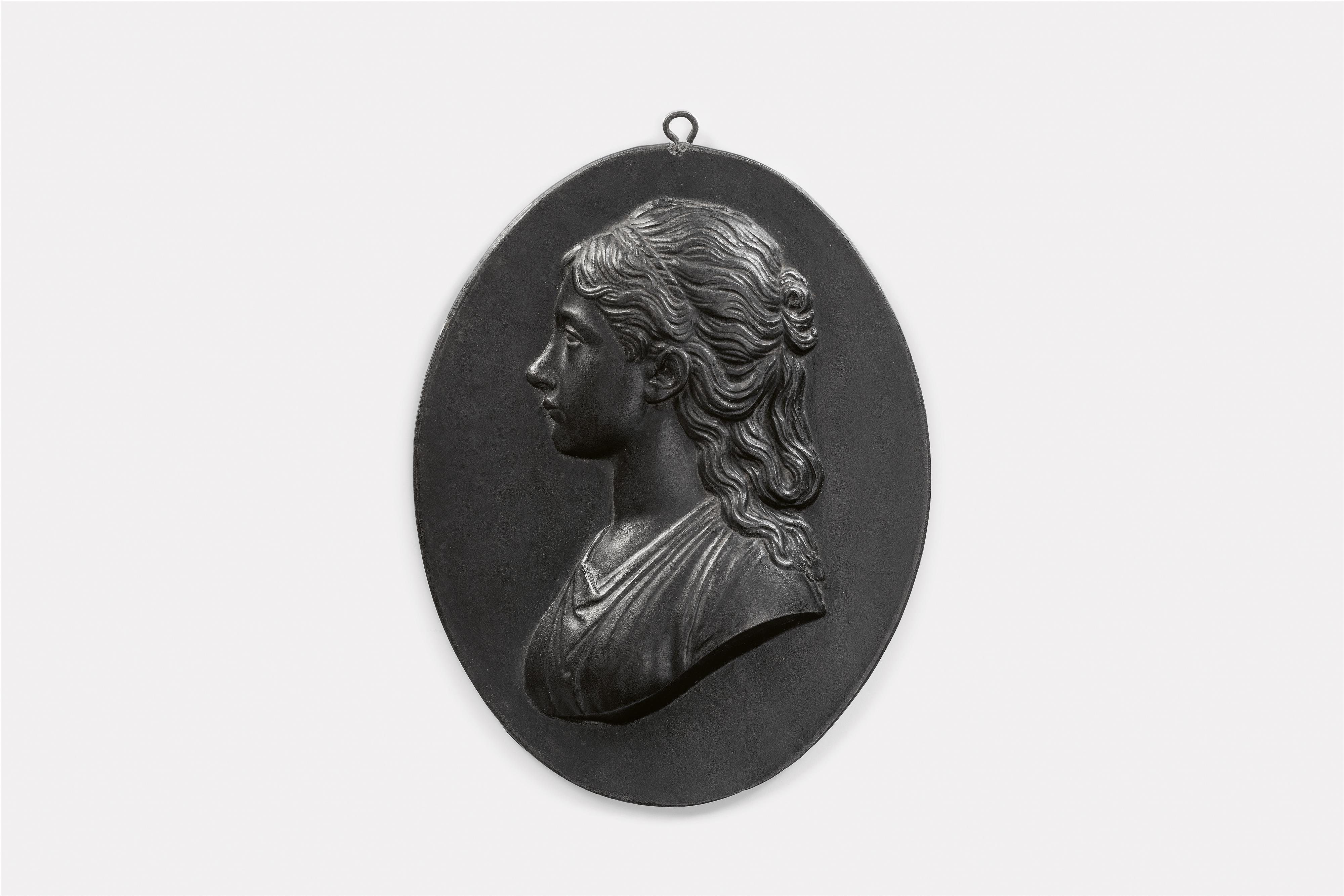 An oval cast iron plaque with a portrait of a lady - image-1