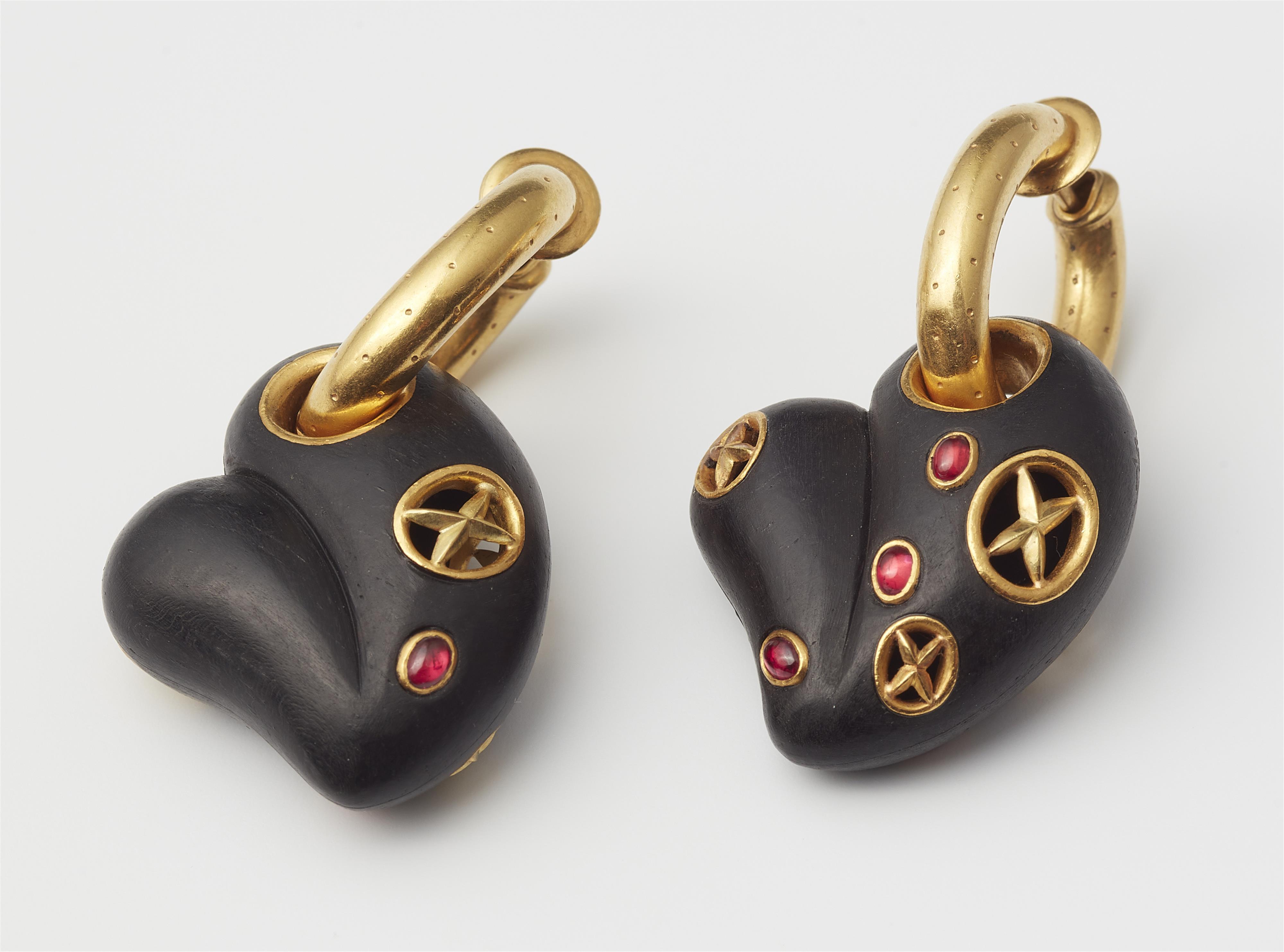 A pair of 18kt gold hoop earrings with ruby set carved ebony heart pendants. - image-2