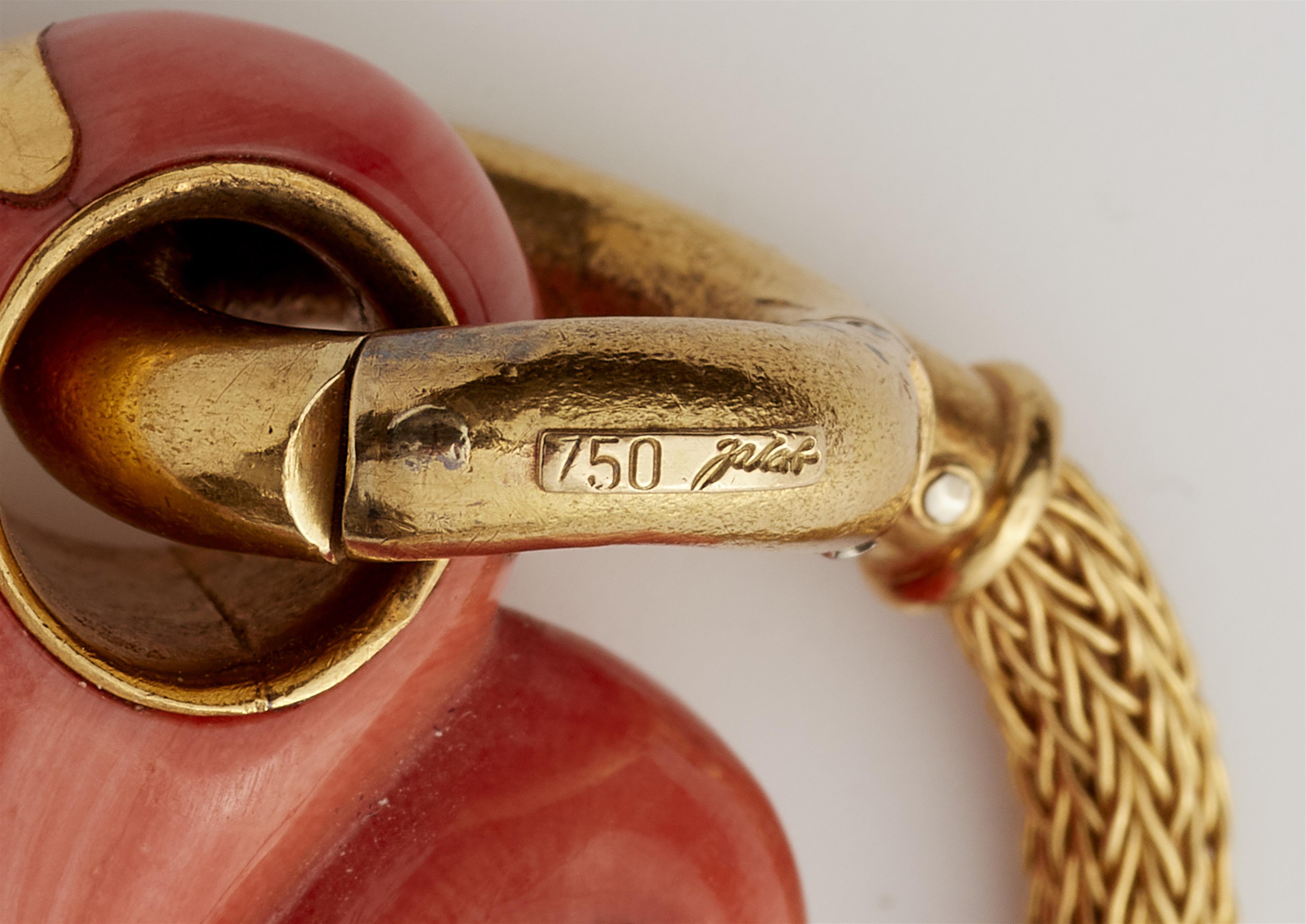 A German18k gold and carved red coral and emerald pin with meshwork connecting chain. - image-3