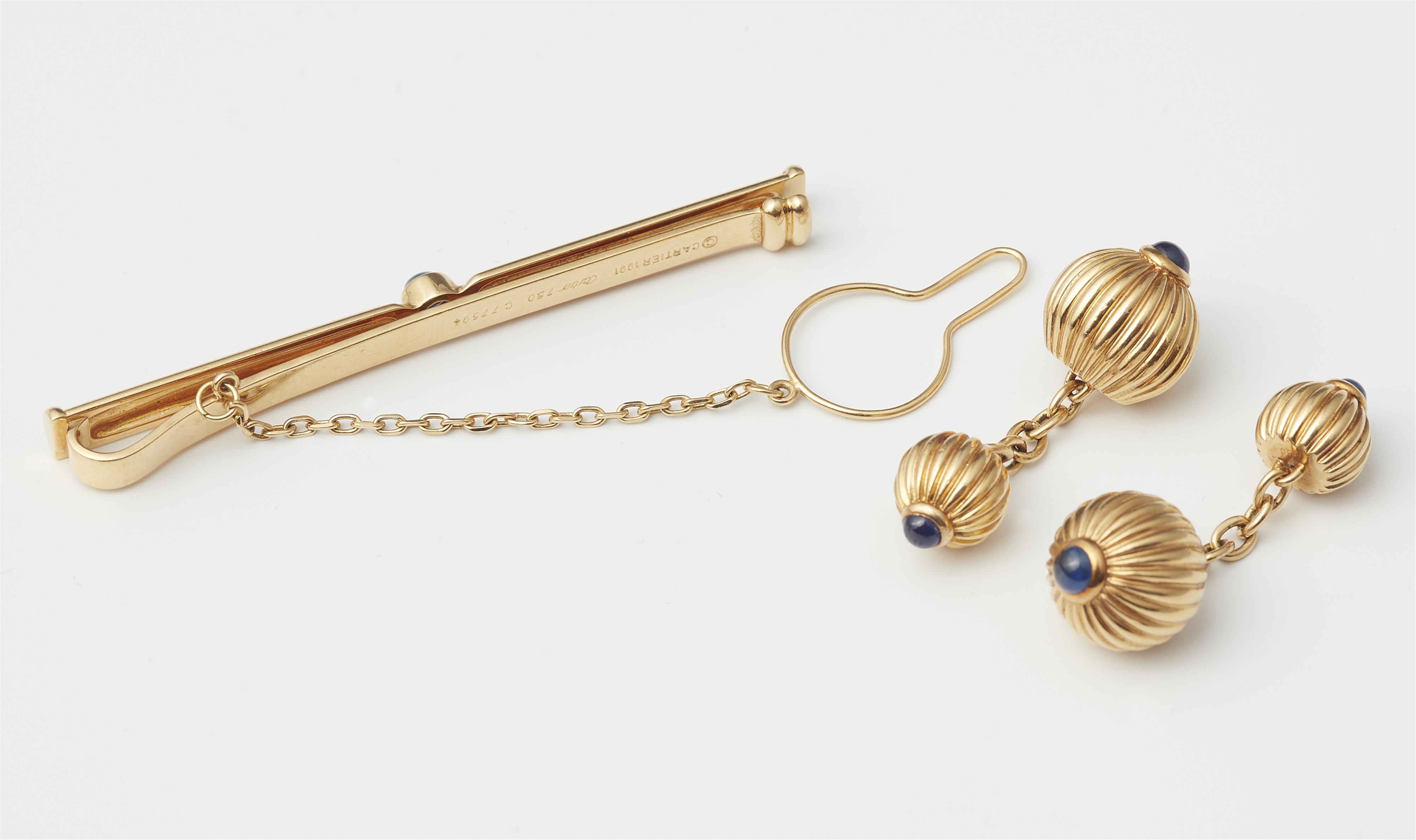 A pair of French godrooned 18k gold and sapphire tie clip and pair of double sided cufflinks. - image-2