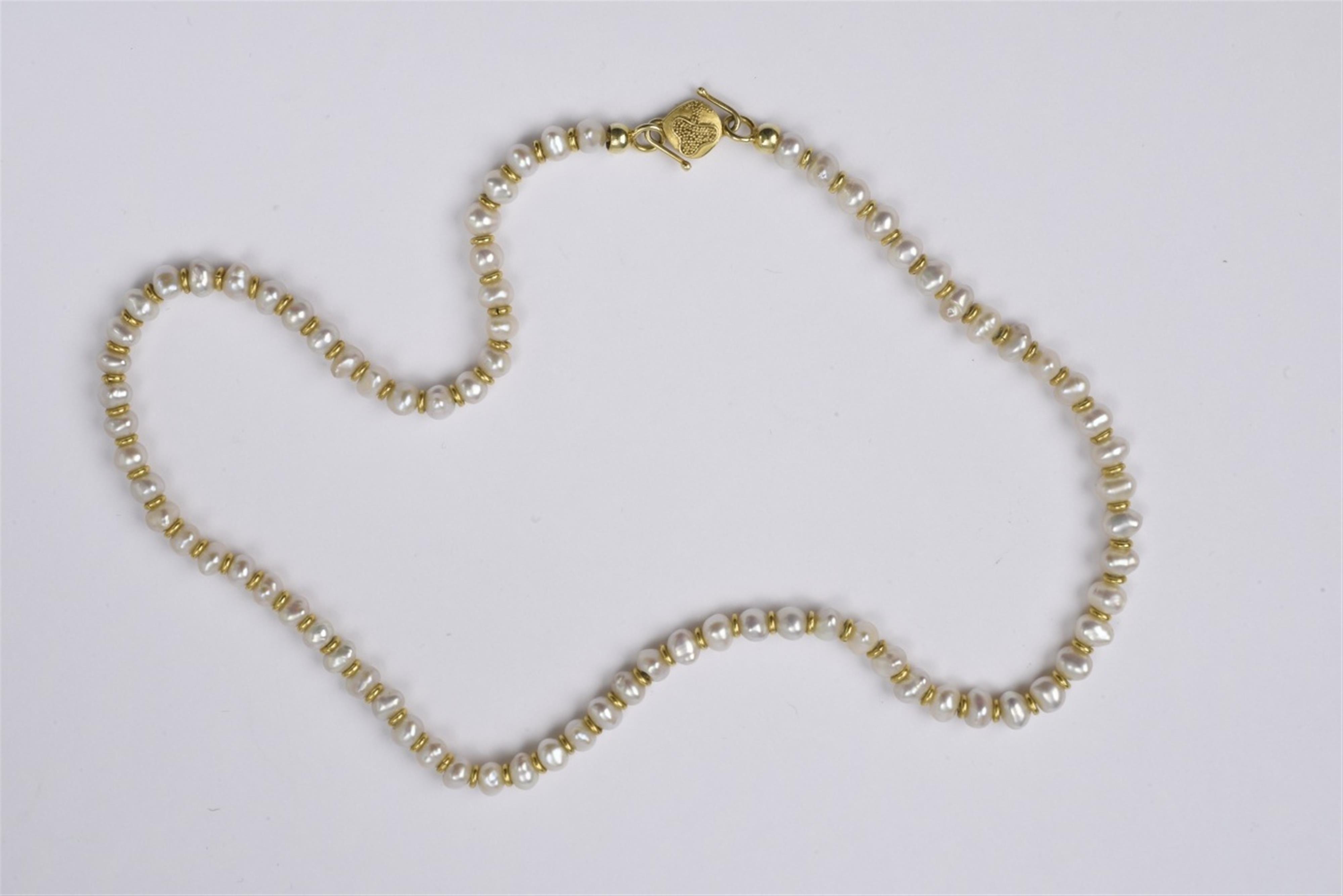 A pearl necklace with a 14k gold clasp - image-1