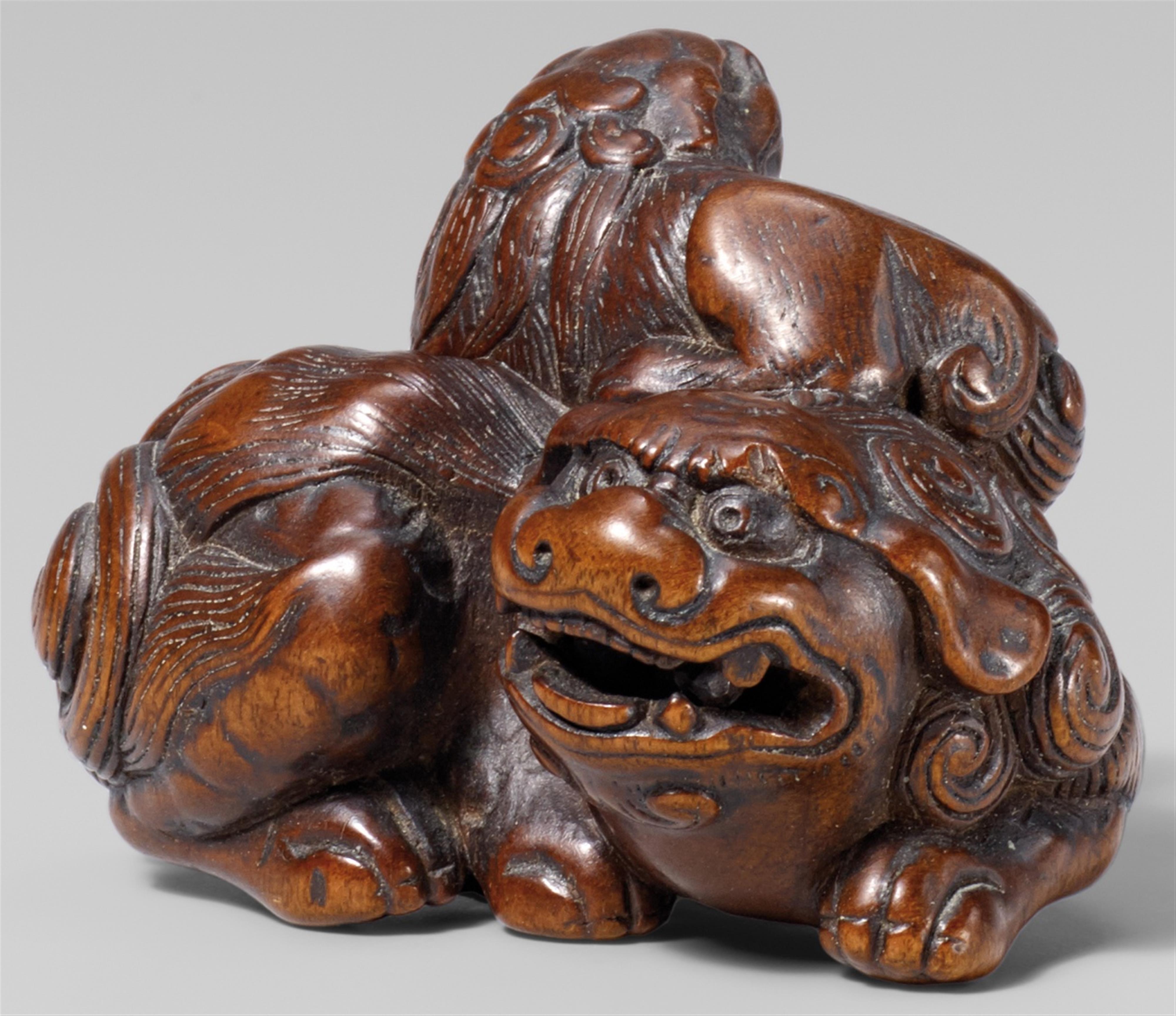 A wood netsuke of a shishi with young. Late 18th/early 19th century - image-1