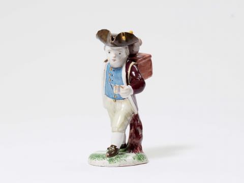A rare Strasbourg faience figure of a boy with a peep-box - 