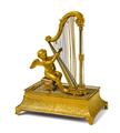 A fire-gilt bronze musical box formed as a putti playing a harp - image-1