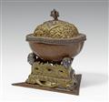 A Tibetan copper kapala with a brass lid and stand with silver details - image-1