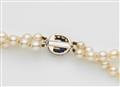 A pearl necklace with a diamond and sapphire clasp - image-2