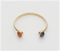 An Austrian 18k gold bangle with two large sapphire cabochons. - image-1