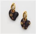 A pair of 18kt gold hoop earrings with ruby set carved ebony heart pendants. - image-1