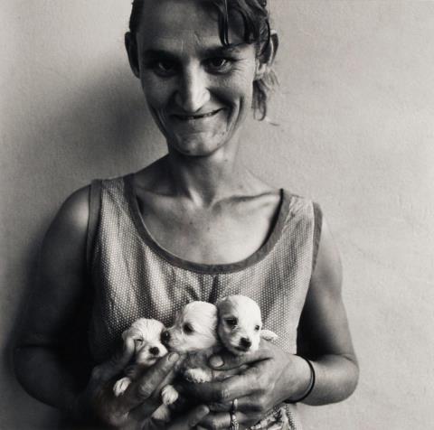 Roger Ballen - Wife of Abattoir worker holding three puppies, Orange Free State