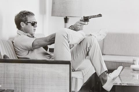 John Dominis - Steve McQueen aims a pistol in his living room