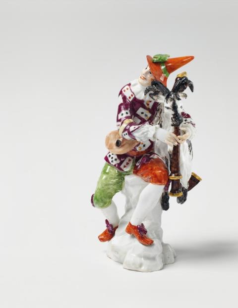 Johann Joachim Kaendler - A rare Meissen figure of a harlequin using a goat as bagpipes.