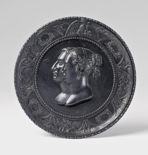  Königliche Eisengießerei Berlin - A black patinated cast iron tondo with a royal double portrait.