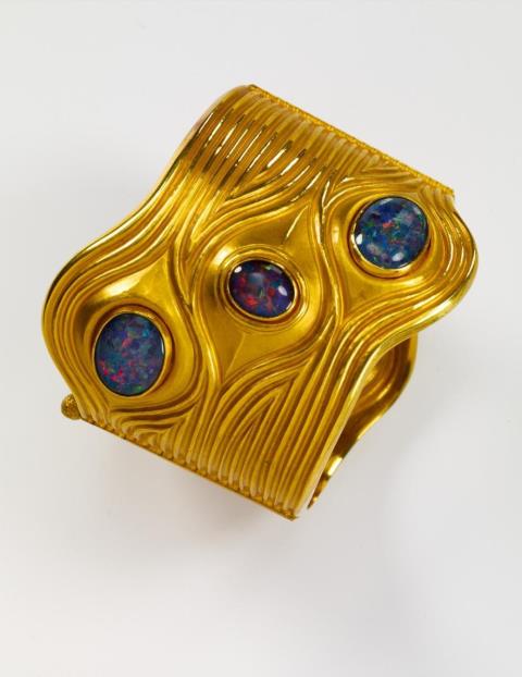 Wilhelm Nagel - A gold linked bangle with opals and ruby cabochons.