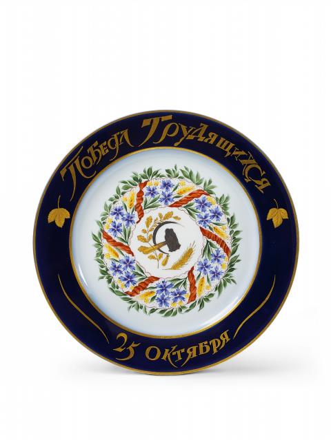 Rudolf Fedorovich Wilde - A porcelain plate centrally decorated with a wreath commemorating the October Revolution, inscribed "Triumph of the labourers 25th October".