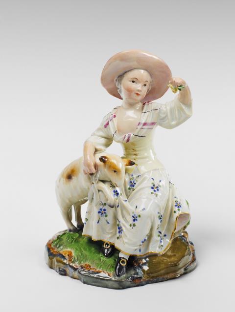 A Höchst porcelain group of a girl shearing a lamb.