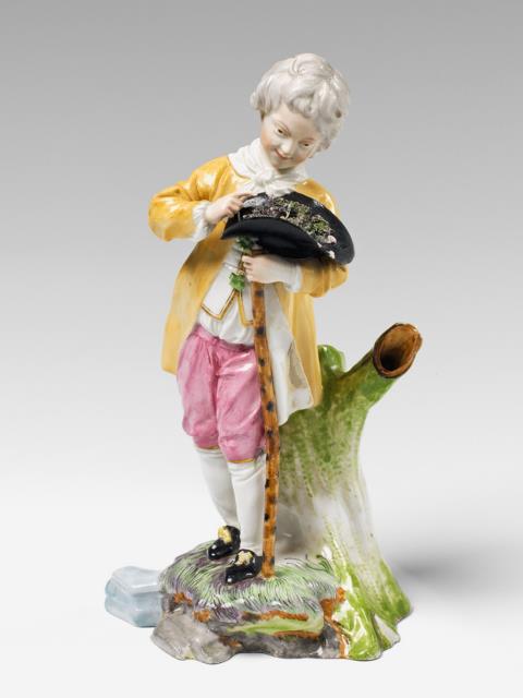 A Höchst porcelain figure of a boy with a bird's nest.