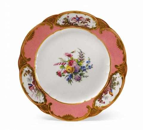 A Sèvres soft paste porcelain plate with floral and exotic bird decor.