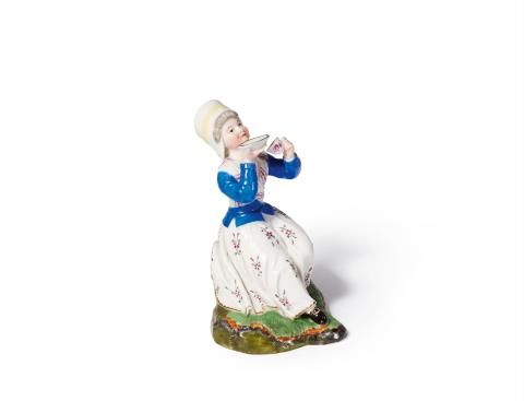 A small Höchst porcelain figure of a lady drinking coffee