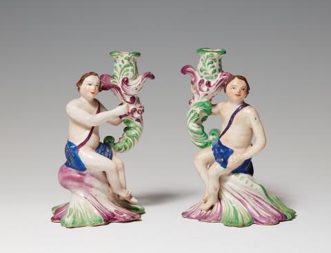  Proskau - A rare pair of faience candlesticks with figural shafts