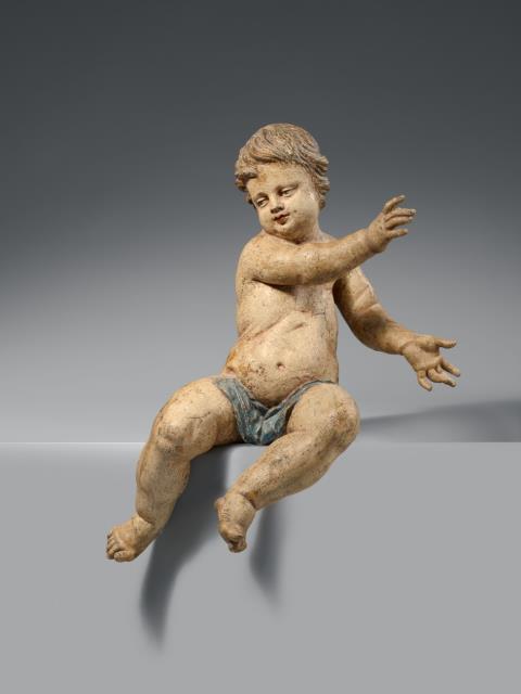 Ferdinand Dietz - A carved wooden figure of a seated Putto