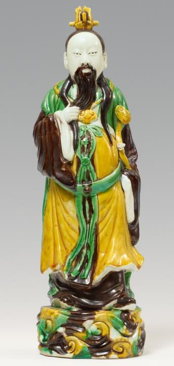 A standing figure of an egg-and-spinach-glazed Daoist deity. Around 1900