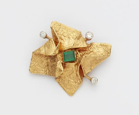 A small 18k gold and emerald brooch