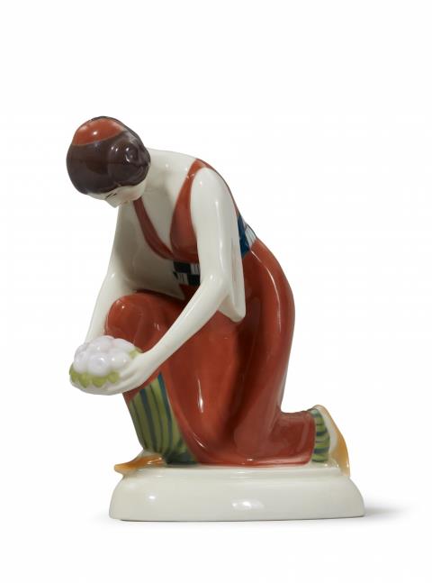 Adolph Amberg - A Berlin KPM porcelain figure of a kneeling Turkish lady with a dish of fruit