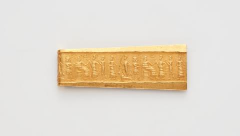 An 18k gold brooch with a cylinder seal impression