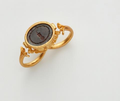 Wolfgang Skoluda - A 22k gold two-finger ring with a late Roman intaglio