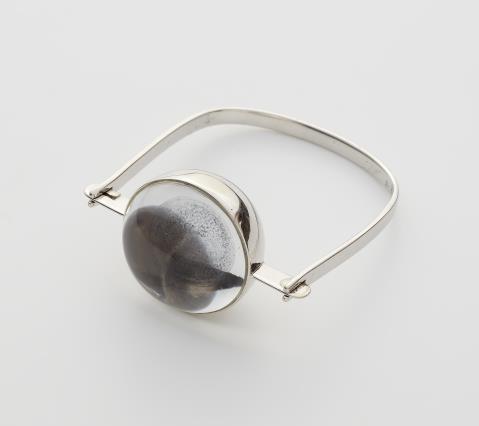 Hans-Leo Peters - A German 18k white gold kinetic bangle with a moving ball in a spherical gold and rock crystal capsule.