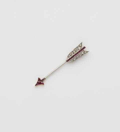 Cartier - A French platinum ruby and diamond arrow jabot pin.